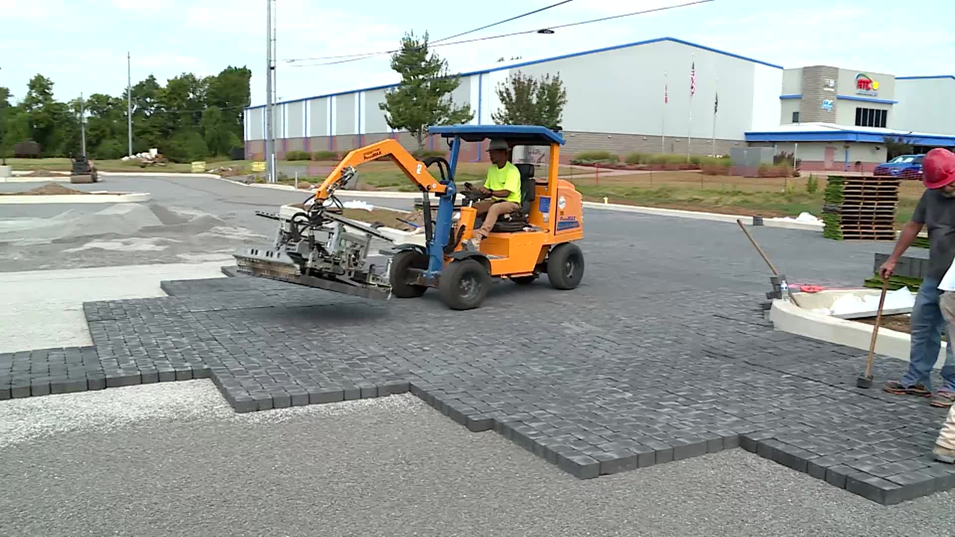 men installing permeable pavers at new baseball field parking lot