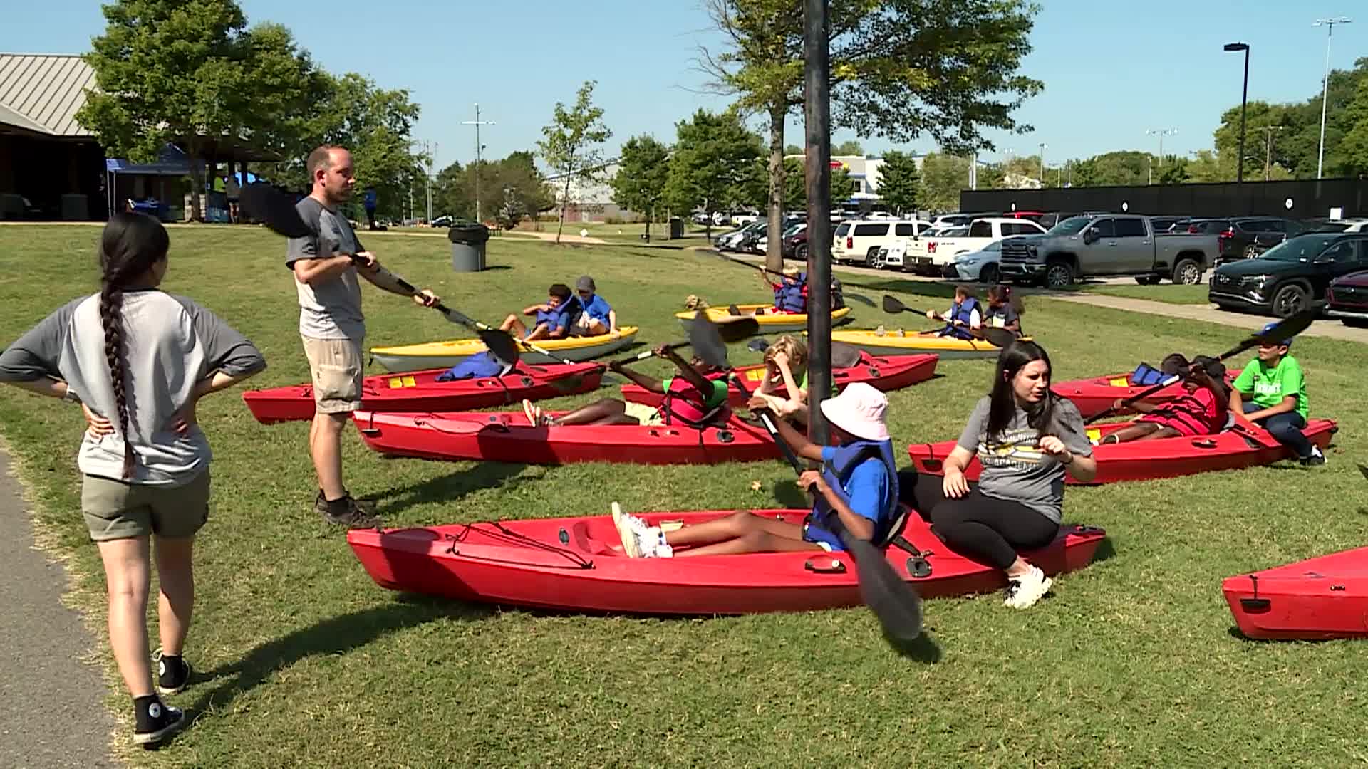 person explaining canoe safety to kids at water fest
