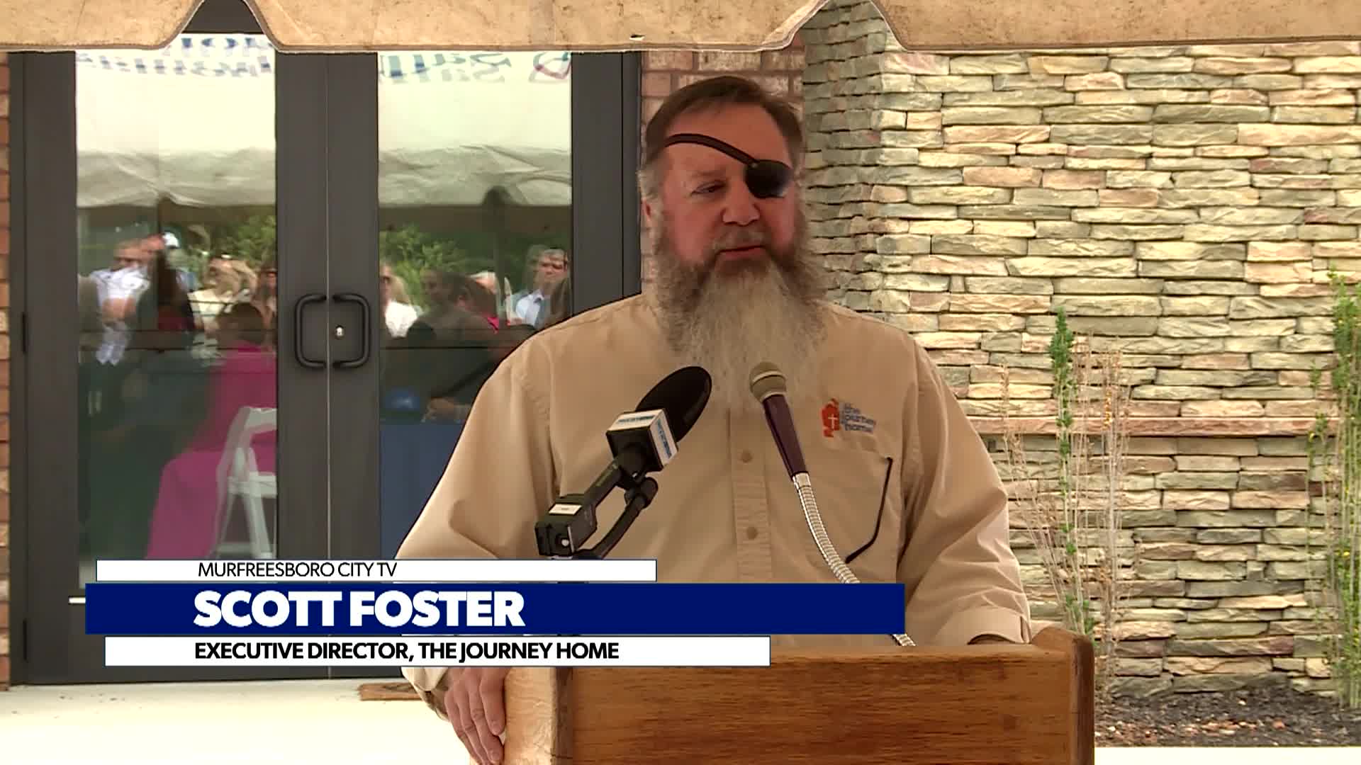 new journey home director speaks to audience at ribbon cutting