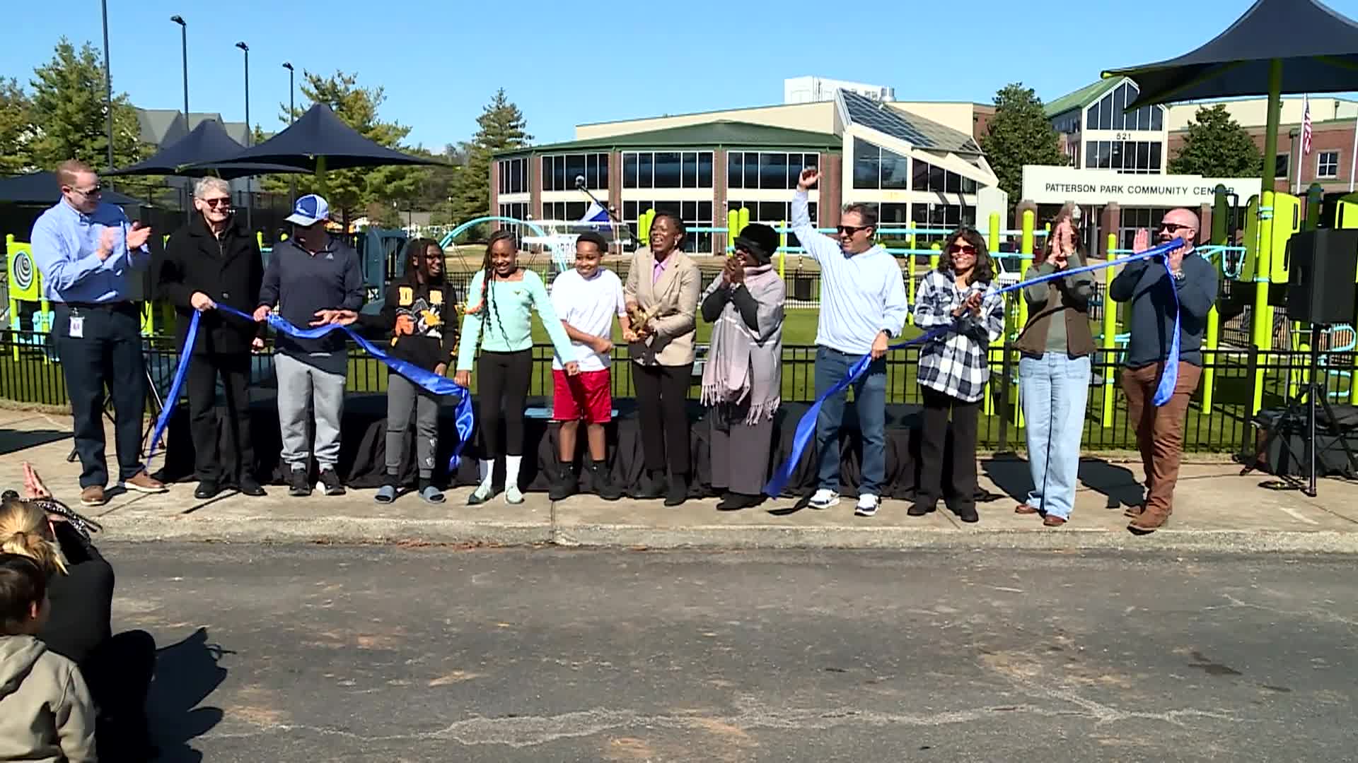 ribbon being cut at the new playground at patterson park community center